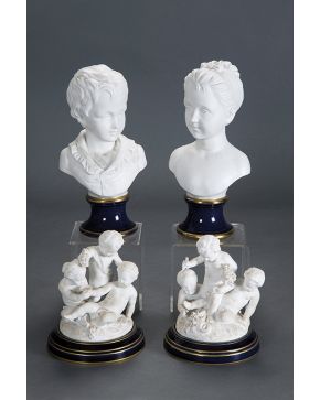 1147-Pareja de bustos de niños en biscuit con marcas KPM. sobre pie y peana en porcelana centroeuropea en azul cobalto con filos dorados. C. 1930. Una cons