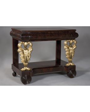 1110-Elegante consola estilo Imperio en madera de caoba con decoraciones en dorado de figuras de dignatarios. Un cajón en cintura.