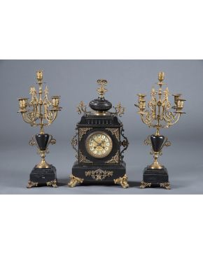 1093-Reloj de sobremesa Napoleón III con guarnición de candelabros de cinco luces en mármol negro y  bronce dorado. Francia. S. XIX. 