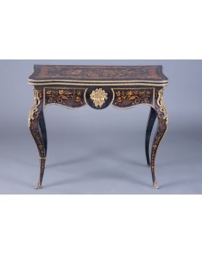 770-Mesa de juego Napoleón III en madera ebonizada con profusa marquetería de flores y perfiles en bronce dorado. S. XIX. Algún desperfecto. 