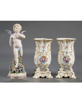 20-Lote en porcelana centroeuropea formado por pareja de jarrones y figura de Cupido con aplicaciones de flores en la base. en porcelana esmaltada  y pin