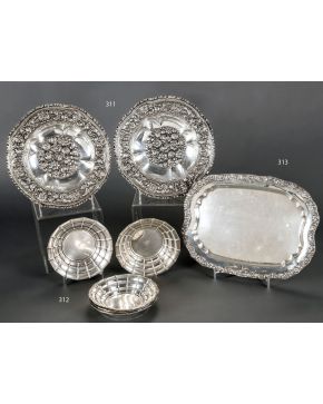 311-Pareja de platos circulares en plata con decoración cincelada de flores. frutos. elementos vegetales y mascarones. C. 1900