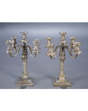 340-Pareja de candelabros de cinco luces en plata española punzonada con fuste a modo de capitel compuesto y decoración vegetal relevada en los brazos.