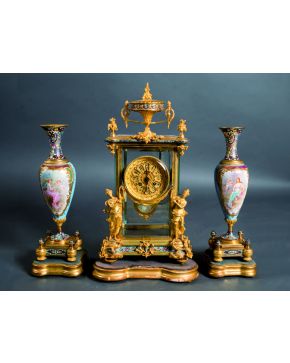 399-Reloj de sobremesa con guarnición de copas en bronce dorado y esmalte cloissoné. Francia. C. 1880. Sobre peanas en madera tallada y dorada.