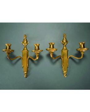 452-Pareja de apliques de dos luces en bronce dorado con fustes acanalados y rematados en forma de pebetero. 