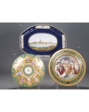 77-Plato en porcelana esmaltada europea. s. XX con la coronación de Napoleón a Josefina en el campo y medallones en el ala con grecas y decoraciones en d