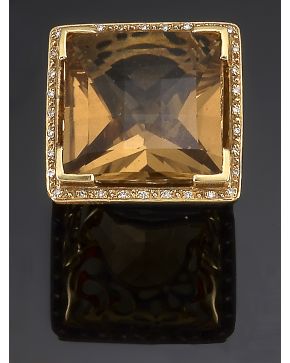 1083- GRAN SORTIJA CON UN TOPACIO DE 20.7CT.APROX ORLADO DE DIAMANTES. Montura de oro amarillo de 18k.