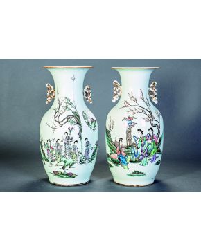 1301-Pareja de jarrones en porcelana china. familia verde. con escena polícroma de damas con paisaje de fondo e inscripciones. Asas caladas en dorado. C. 1