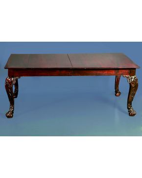 663-Mesa de comedor en madera de caoba estilo inglés. Patas con decoración vegetal terminadas en garra sobre bola. S. XIX.