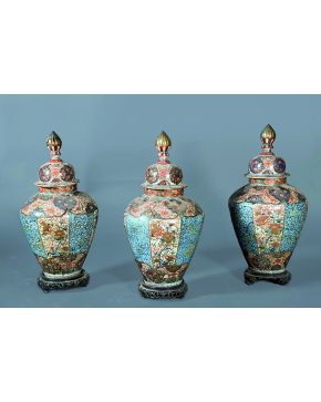 1329-Conjunto de tres tibores en porcelana japonesa polícroma decorada con frisos verticales y horizontales de profusa vegetación sobre fondo azul claro y 