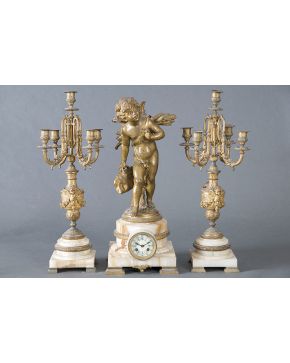 712-Reloj francés con guarnición de candelabros de 5 luces en mármol rosa y bronce dorado. c.1920. Esfera en porcelana blanca con numeración romana en azu