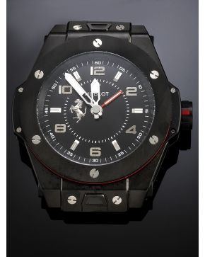 1075-2. DESPERTADOR HUBLOT MODELO BIG BANG FERRARI. GRAN CAJA EN ACERO NEGRO. MOVIMIENTO SUIZO DE CUARZO. Esfera negra con numeración arábiga y a trazo