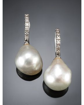 720-PENDIENTES COLGANTES CON UNA GRAN PERLA AUSTRALIANA BARROCA. de intenso oriente. Sobre una montura de finas garras en oro blanco de 18k.