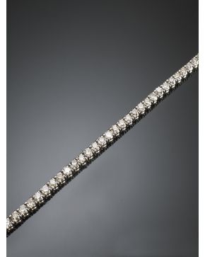 817-ELEGANTE PULSERA RIVIERE DE BRILLANTES DISPUESTOS EN GARRAS. Montura en oro blanco de 18k. 