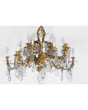 805-Gran lámpara de techo en bronce dorado de 24 luces con brazos decorados con elementos vegetales y rocallas. Cuentas de cristal y pandelocas colgantes.