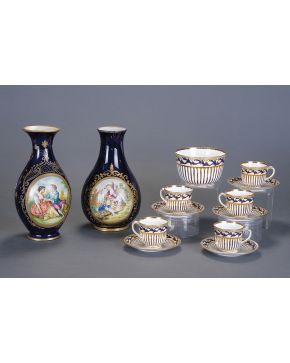 1009-Lote de dos jarrones en porcelana esmaltada tipo Sévres decorados con instrumentos musicales en dorado y escenas pastoriles en reserva.