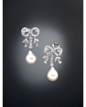 461-PENDIENTES COLGANTES CON PERLA EN FORMA DE PERA  CON DIAMANTES SOBRE MONTURA EN FORMA DE LAZO de oro blanco de 18k.