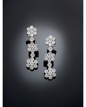 558-ELEGANTES PENDIENTES COLGANTES DE DIAMANTES CON FORMA DE TRES FLORES sobre montura de oro blanco de 18k.