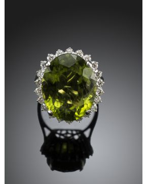 650-SORTIJA DE GRAN PERIDOTO OVAL DE 12 CTS ORLADO DE DIAMANTES sobre montura de oro blanco de 18k. 