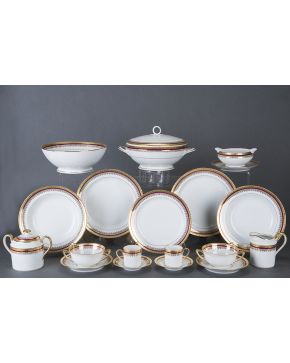 1313-Moderna vajilla en porcelana esmaltada de Limoges con decoración en dorado y filo en granate. Con marcas: Jammet-Seignolles.