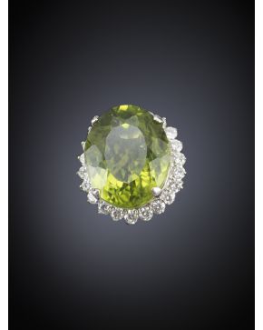 377-SORTIJA DE GRAN PERIDOTO OVAL DE 12 CTS ORLADO DE DIAMANTES sobre montura de oro blanco de 18k. 