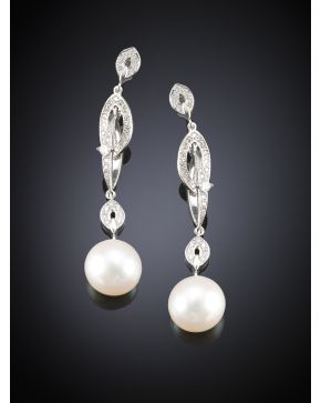 677-MODERNOS PENDIENTES DECORADOS CON BRILLANTES DE LOS QUE PENDEN UNA PERLA AUSTRALIANA.DE BELLO ORIENTE DE 9.5 MM APROX.. Montura de oro blanco de 18 k.