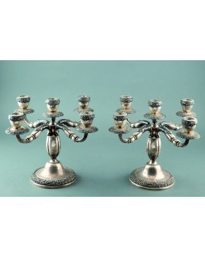 891-Pareja de candelabros de cinco luces en plata española punzonada C. 1940. con decoración relevada de motivos vegetales.