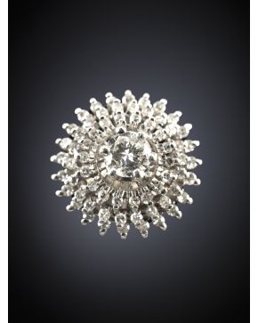 106-SORTIJA CON UN BRILLANTE CENTRAL DE 0.23 CT.APROX. ORLADO DE PEQUEÑOS BRILLANTES EN FORMA DE FLOR. Montura en oro blanco de 18k.