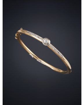 349-PULSERA RÍGIDA ANTIGUA CON UN CENTRO DE DIAMANTE FLANQUEADO POR FINA HILERA DE DIAMANTES. Montura de oro amarillo y blanco de 18k.