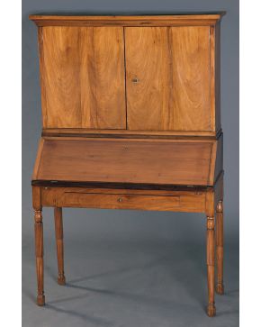 1235-Mueble escritorio. s. XIX. en madera tallada con cuerpo superior con doble puerta y estantes interiores. tapa abatible y cajón en cintura. Con llave.