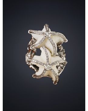 107-MODERNO ANILLO MARINO CON DOS ESTRELLAS DE MAR DE CORAL BLANCO DECORADAS CON LÍNEAS DE BRILLANTES. Montura en oro blanco de 18k. Peso total de los bri