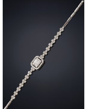 377-PULSERA CON BRILLANTE CENTRAL TALLA BAGUETTE ORLADO DE CHISPITAS DE BRILLANTES E HILERA DE BRILLANTES A AMBOS LADOS. Montura en oro blanco de 18k.