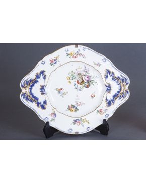 1166-Gran fuente oval en porcelana esmaltada francesa con decoración de frutos. flores y detalles en dorado y azul cobalto. Finales s. XIX. Con marcas.