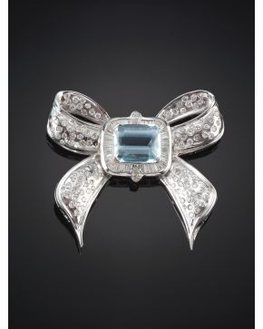 209-ELEGANTE BROCHE EN FORMA DE LAZO CON AGUAMARINA CENTRAL DE 5 CT APROX.  CALIDAD EXTRA POR SU COLOR Y PUREZA. ORLA DE DIAMANTES TALLA BAGUETTE Y DIAMAN