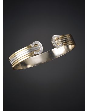 836-BRAZALETE RÍGIDO ESTRIADO CON TERMINACIONES DE BRILLANTES.Montura en oro blanco y oro amarillo de 18k.