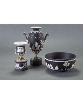 1032-Lote en biscuit de Wedgood formado por cuenco. copa y jarrón con decoraciones clásicas sobre fondo negro.