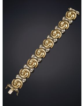 806-MODERNO BRAZALETE DE LÍNEAS CIRCULARES ENTRERLAZADAS EN ORO AMARILLO Y BLANCO LISO DE 18 K.