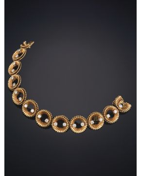 816-VAN CLEEF & ARPELS ELEGANTE PULSERA. AÑOS 50. DE BELLAS FORMAS GEOMÉTRICAS GRANULADAS EN ORO AMARILLO DE 18K DECORADA POR BRILLANTES.