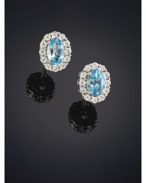 318-BELLOS PENDIENTES DE TOPACIOS AZULES ORLADOS POR BRILLANTES sobre una montura de oro blanco de 18K.