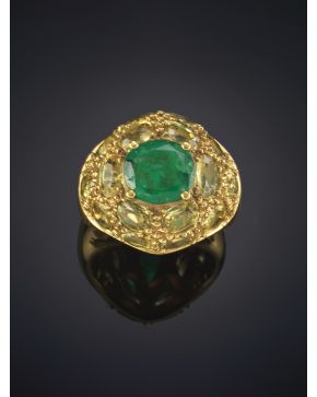 369-ORIGINAL SORTIJA CON UNA ESMERALDA CENTRAL SOBRE UNA MONTURA BOMBÉ DE PERIDOTOS. en oro amarillo de 18K. 