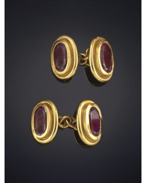 438-ELEGANTES GEMELOS DE FORMA OVAL CON UN RUBÍ CENTRAL sobre una montura de oro amarillo de 18K.