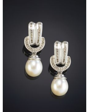 589-ELEGANTES PENDIENTES CON PERLAS CULTIVADAS QUE PENDEN DE UN ESLABÓN CUAJADO DE BRILLANTES sobre una montura en oro blanco de 18K.