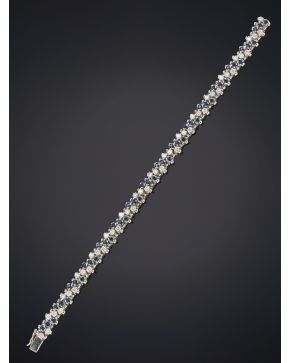 863-ELEGANTE PULSERA DE BRILLANTES Y ZAFIROS SOBRE UNA MONTURA ARTICULADA EN ORO BLANCO DE 18K.