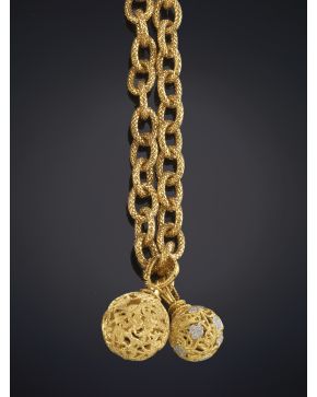 116-CADENA LARGA DE ESLABONES ENTRELAZADOS EN ORO AMARILLO LABRADO CON DOS COLGANTES ESFÉRICOS DECORADOS CON PAVÉ DE BRILLANTES. En oro amarillo de 18K.