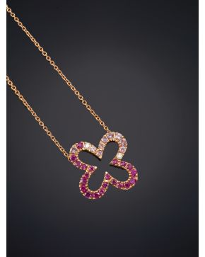 265-BELLO COLGANTE CON UNA FLOR DECORADA CON BRILLANTES Y RUBÍES sobre una fina montura y cadena en oro rosa de 18K.