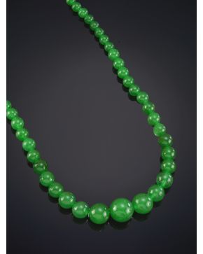 38-PULSERA RÍGIDA EN JADE VERDE CON UNA GARGANTILLA A CONJUNTO DE CUENTAS DE JADE EN LIGERO DEGRADÉ DE INTENSO COLOR VERDE.