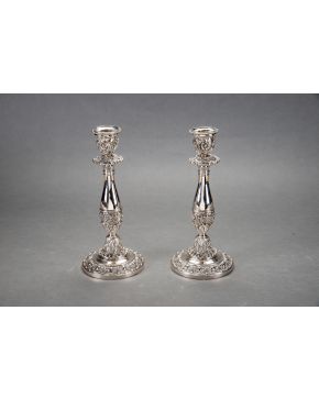 1129-Pareja de candeleros en plata con decoración relevada de motivos vegetales y espejuelos. 