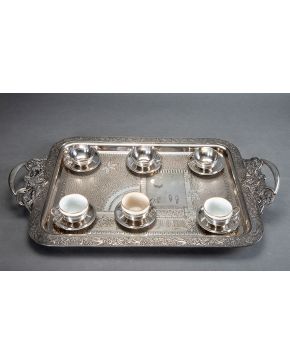 965-Lote formado por juego de café de 6 tazas con sus platos en plata española punzonada y bandeja rectangular con asas y decoración orientalista. ff. s. 