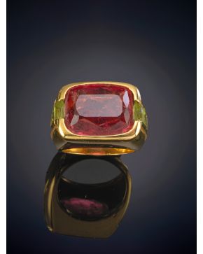 146-SORTIJA CON GRAN TURMALINA ROSA FLANQUEADA POR TRÍOS DE PERIDOTOS SOBRE UNA GRAN MONTURA EN ORO AMARILLO DE 18K. 