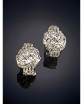 148-ELEGANTES PENDIENTES EN FORMA DE NUDO CUAJADOS DE BRILLANTES Y DIAMANTES TALLA BAGUETTE sobre una montura en oro blanco de 18K.